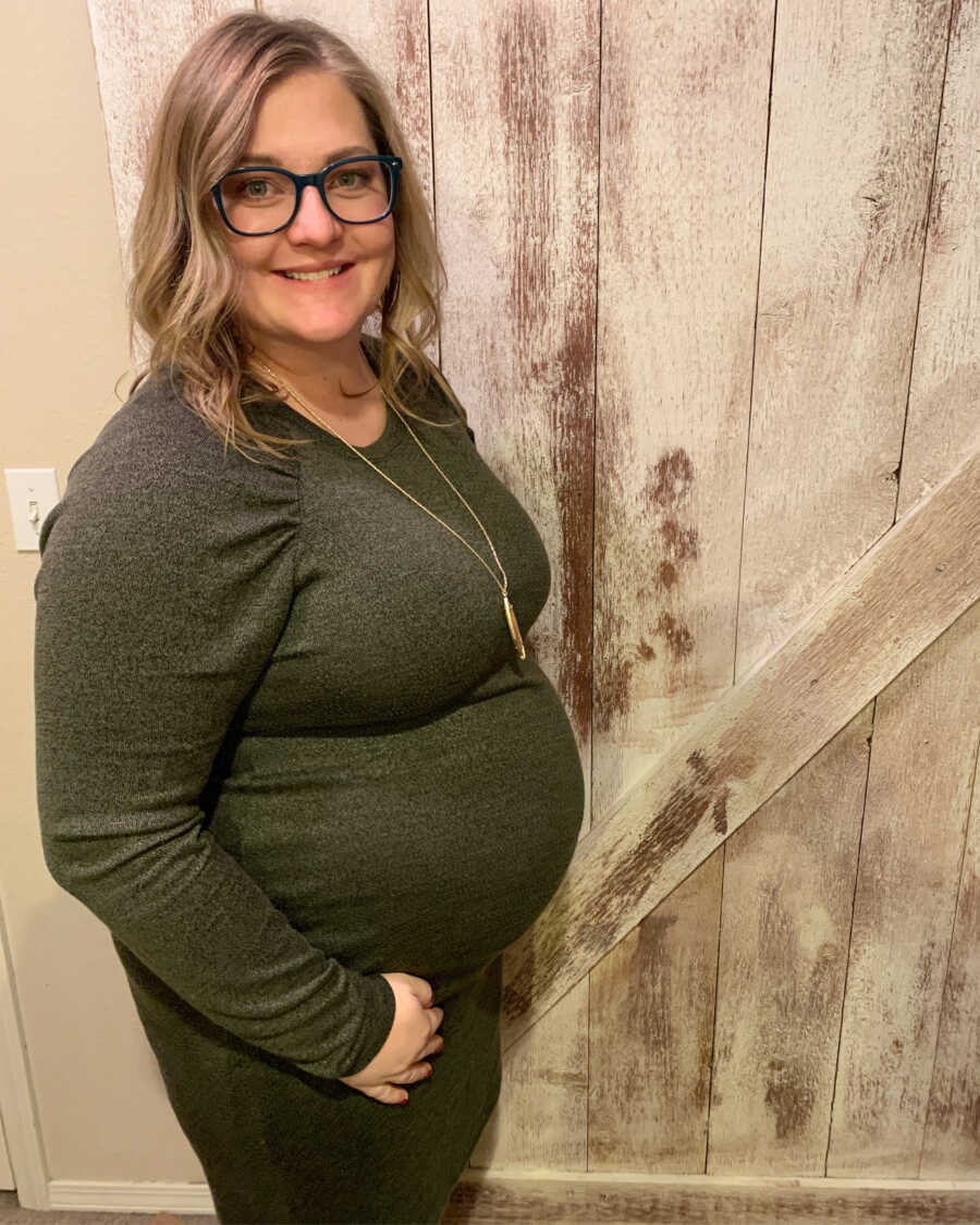 Pregnant woman standing in front of barn door