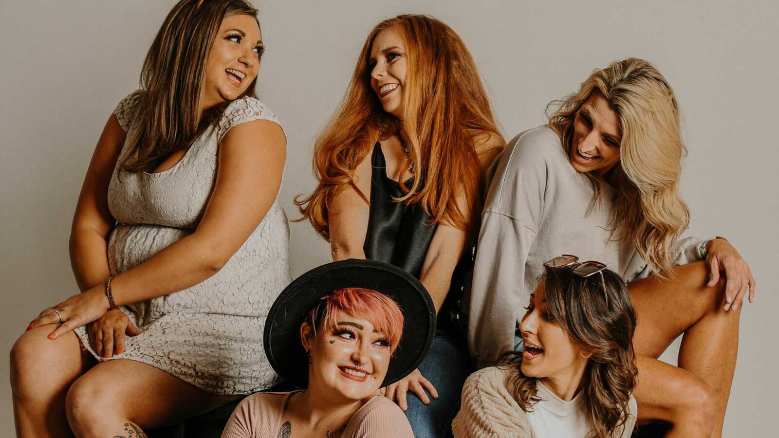 group of 5 women laughing together