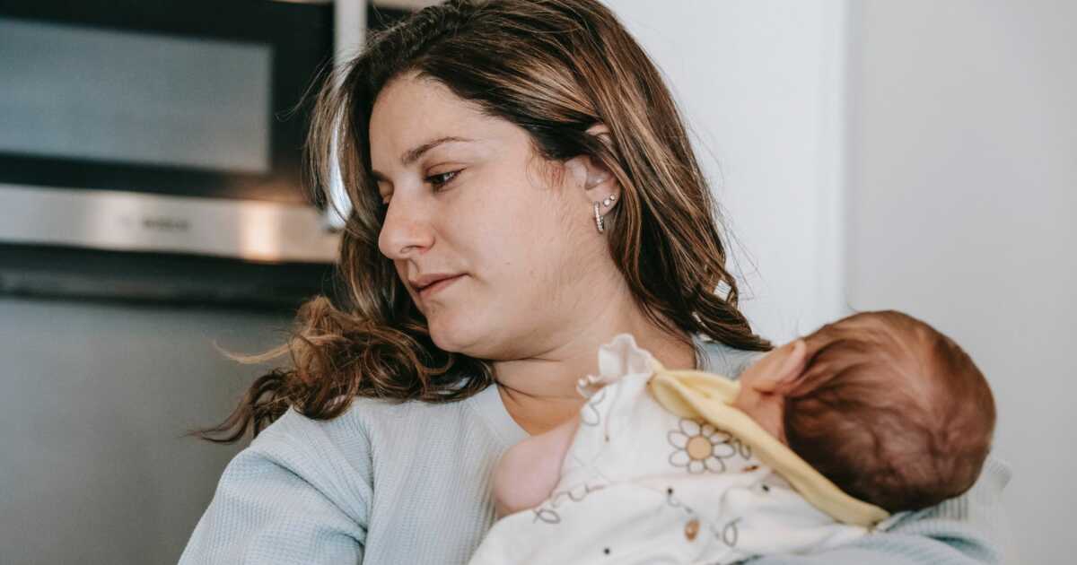 white mom holding newborn baby