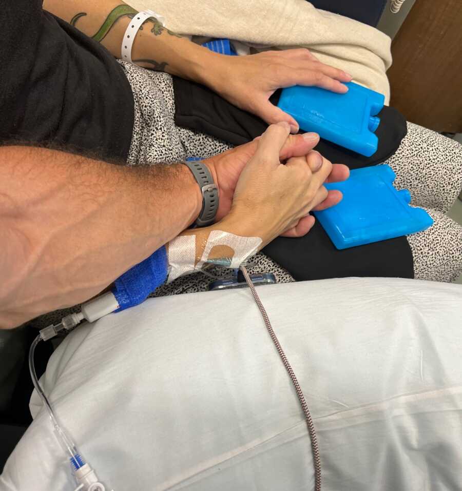 Boyfriend and girlfriend holding hands during chemotherapy treatment