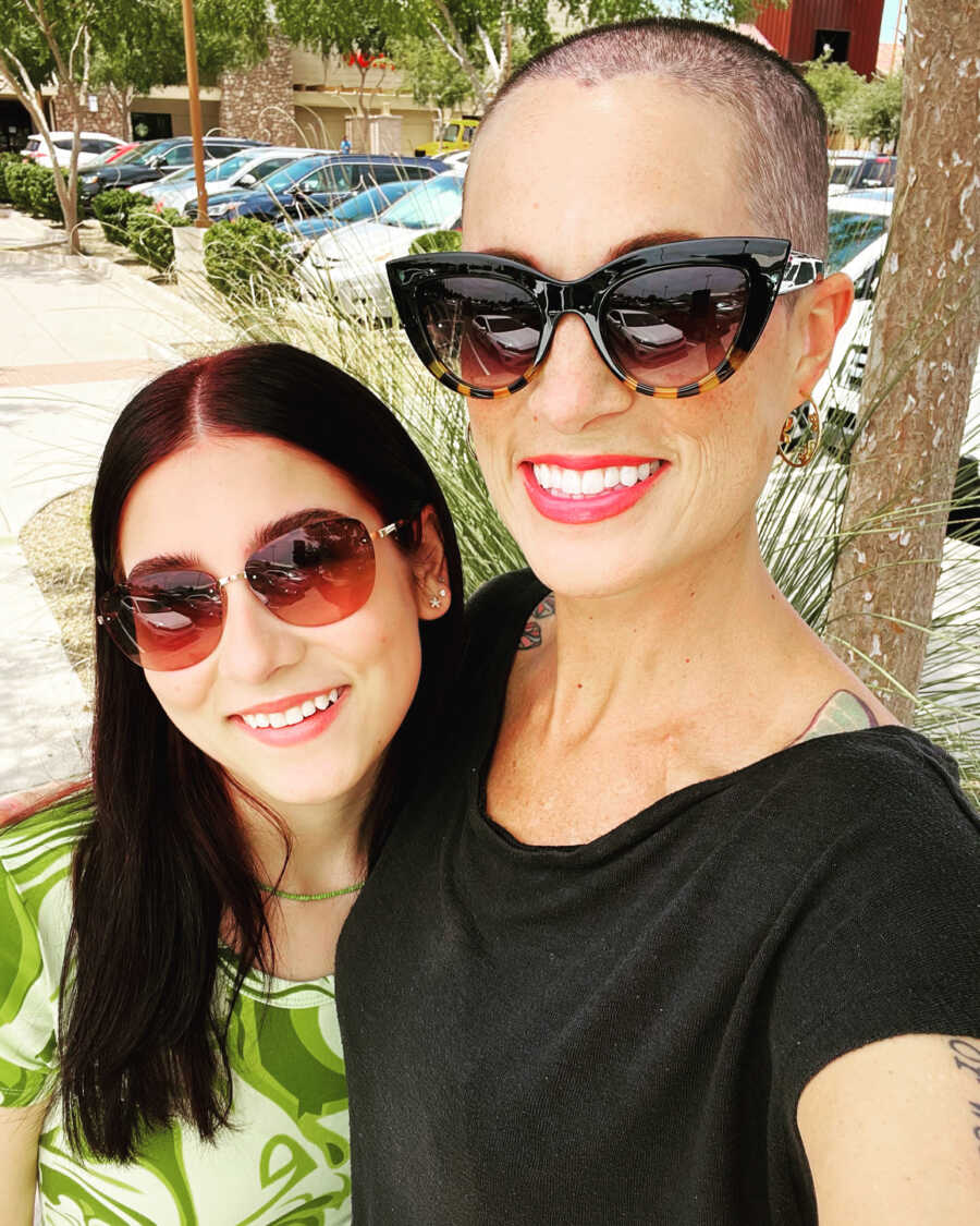 Mom and daughter smiling in sunglasses