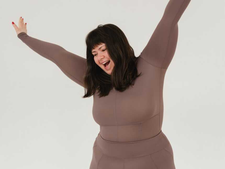 happy plus size woman holding arms up