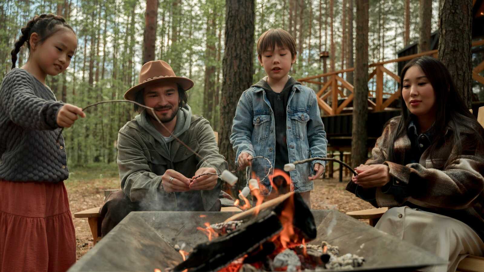 family of four roasting marshmallows on a campfire