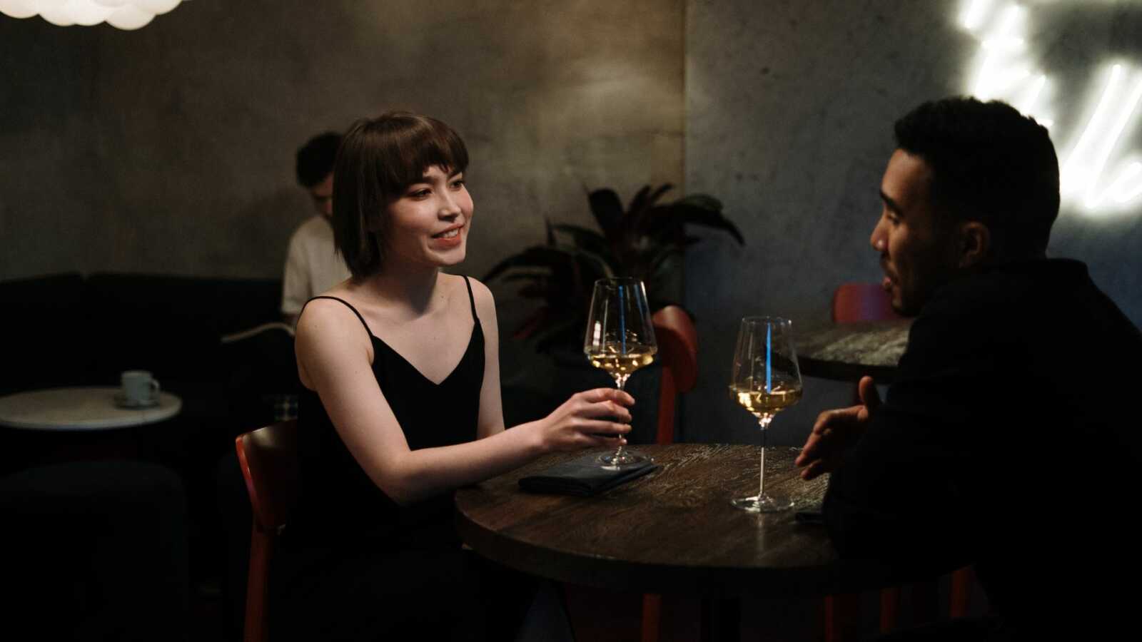 a woman and a man on first date at a wine bar