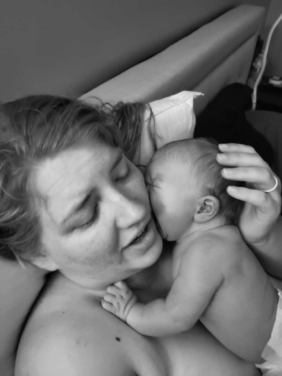 Mother holds newborn baby against her cheek