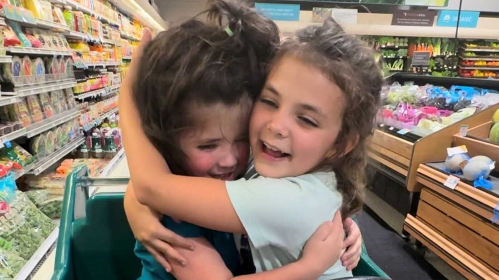 Sisters embrace in grocery cart