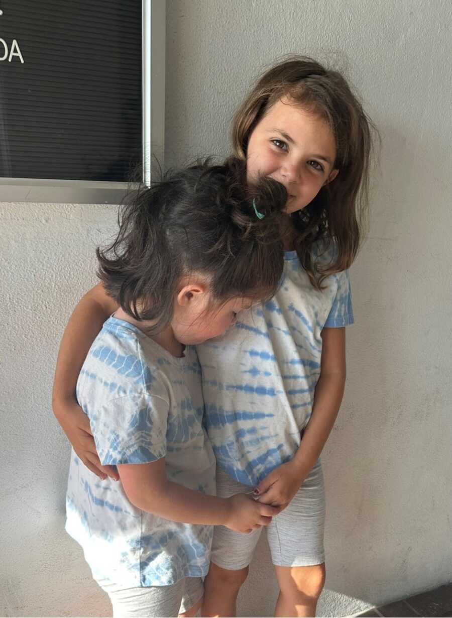 Sisters pose while wearing matching tie-dye shirts