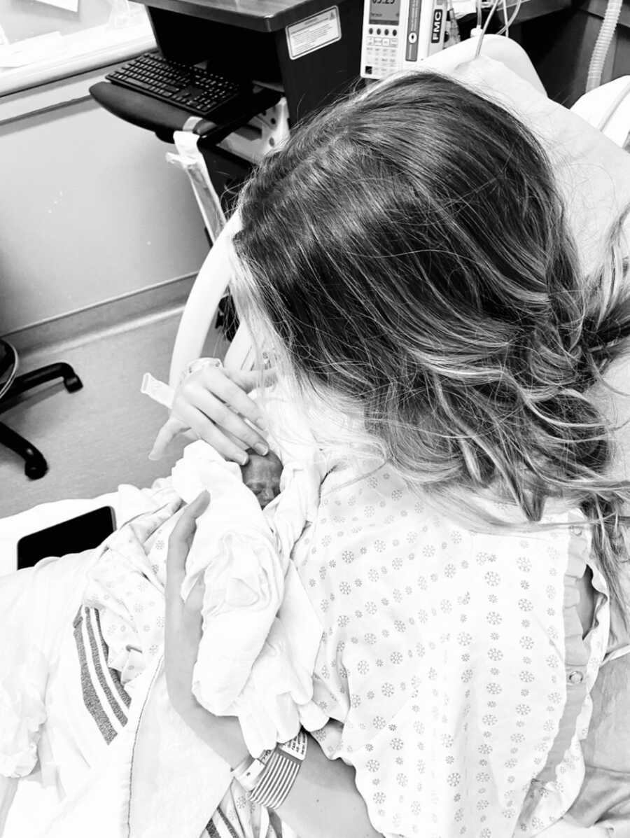 Mother holds stillborn daughter in hospital bed