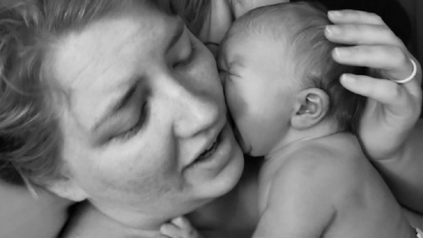 Mother holds newborn against her cheek