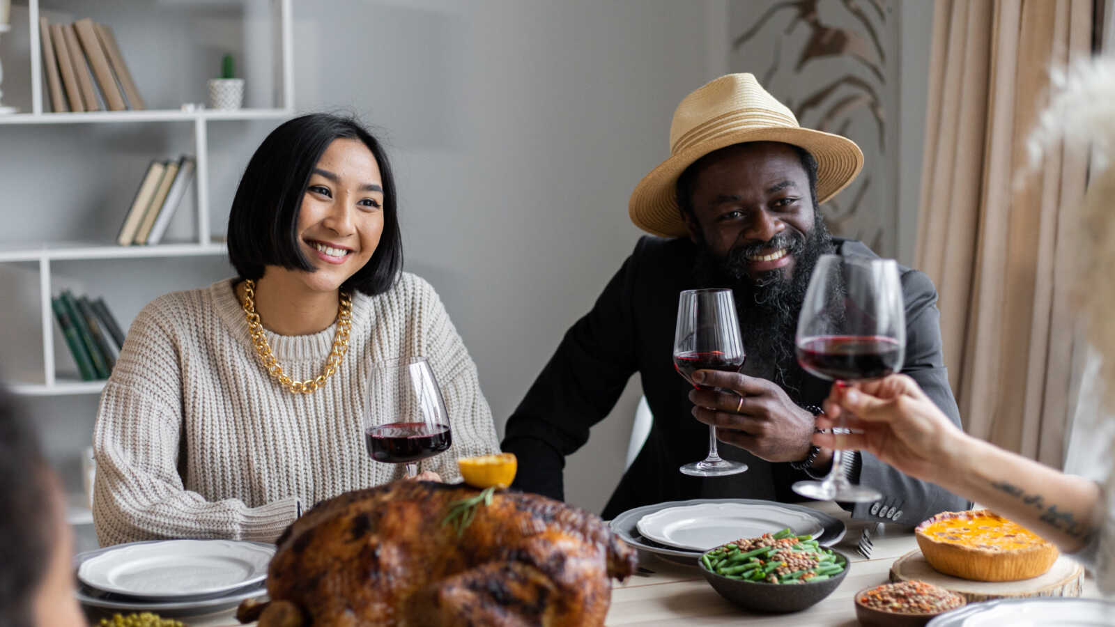a couple sits together with wine at a thanksgiving table
