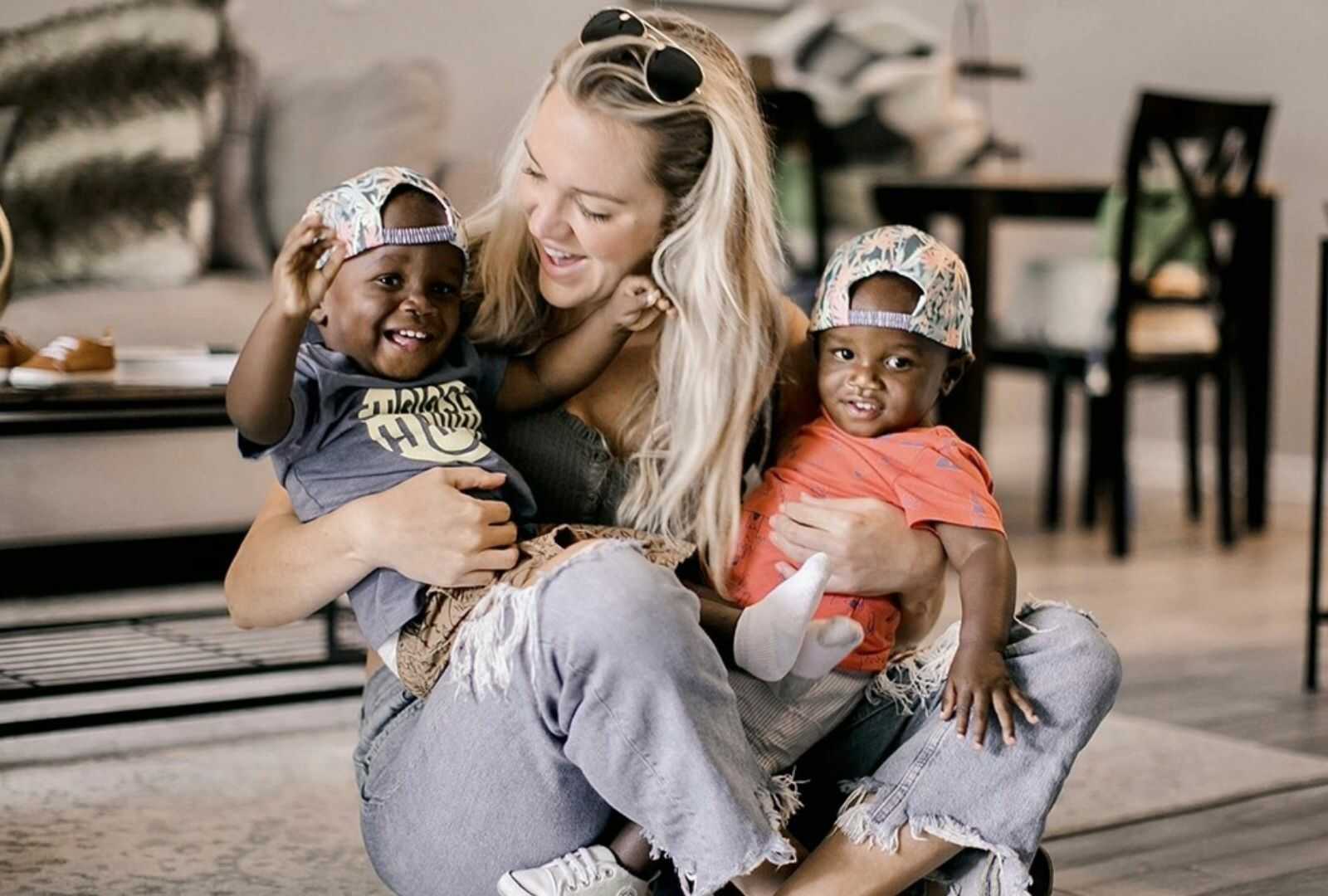 Single foster mom holding smiling twins in lap