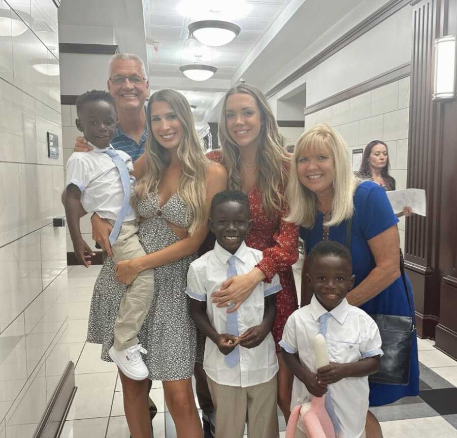 Family smiling inside adoption court house