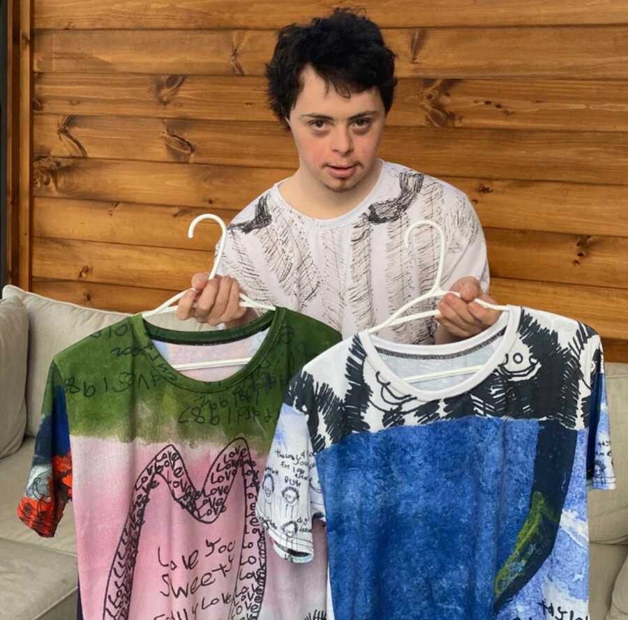 Man with Down syndrome holding custom-printed shirts