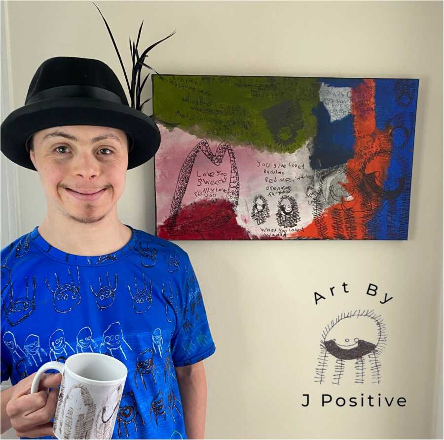 Man with Down syndrome smiling next to artwork