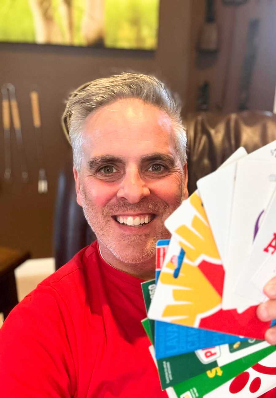Man holding multiple gift cards
