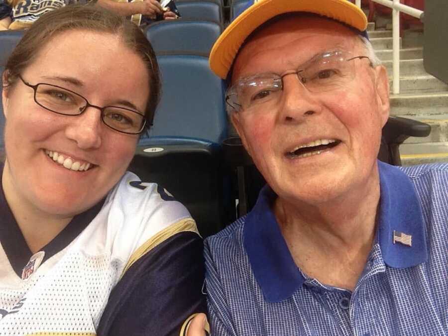 Smiling woman sitting next to grandpa at sports game