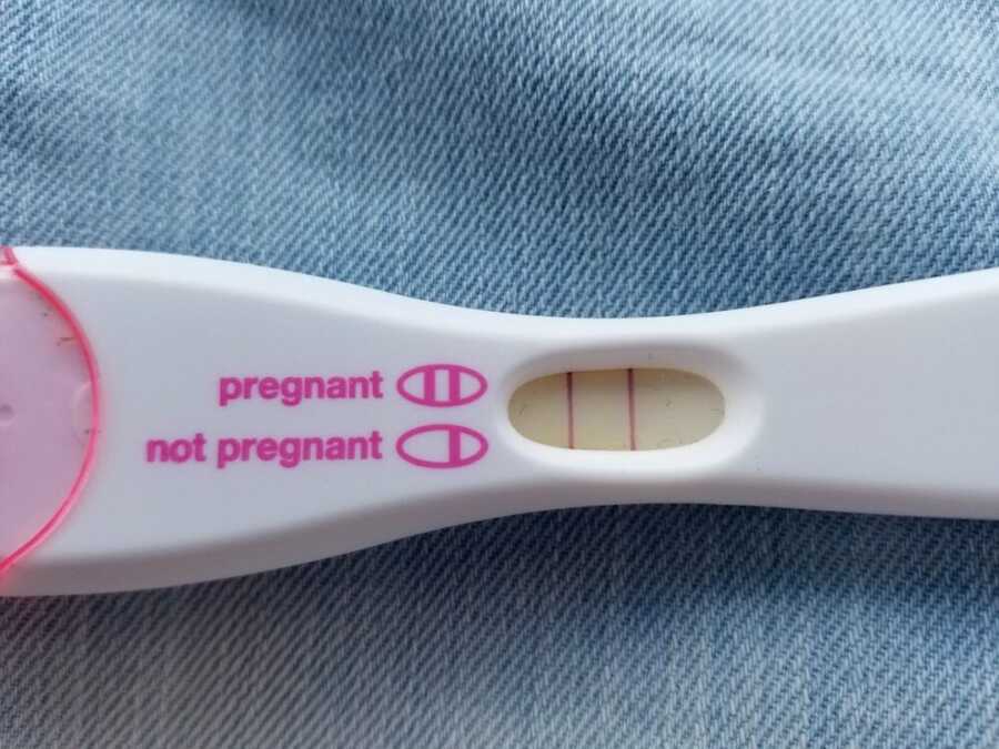 Positive pregnancy test lying on jeans