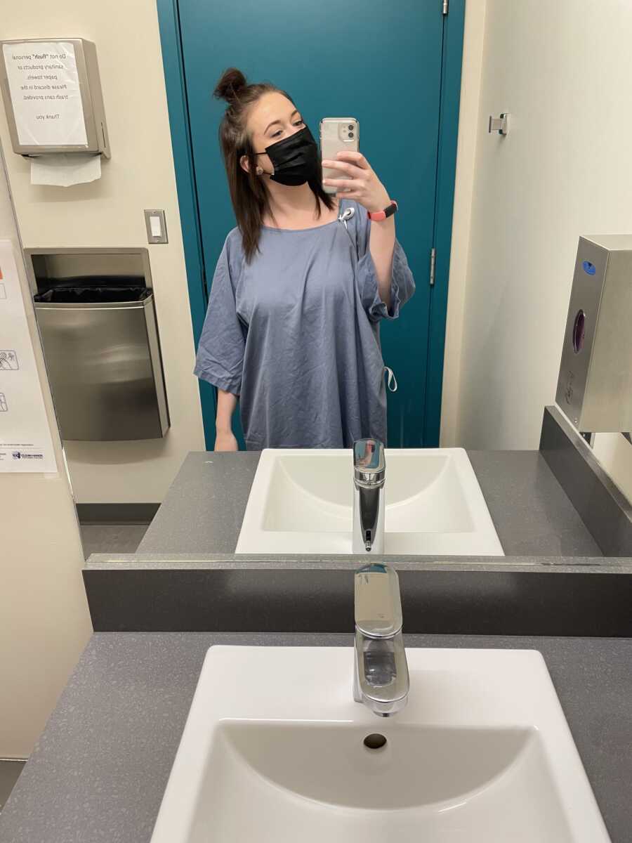 Patient wearing black mask inside hospital bathroom