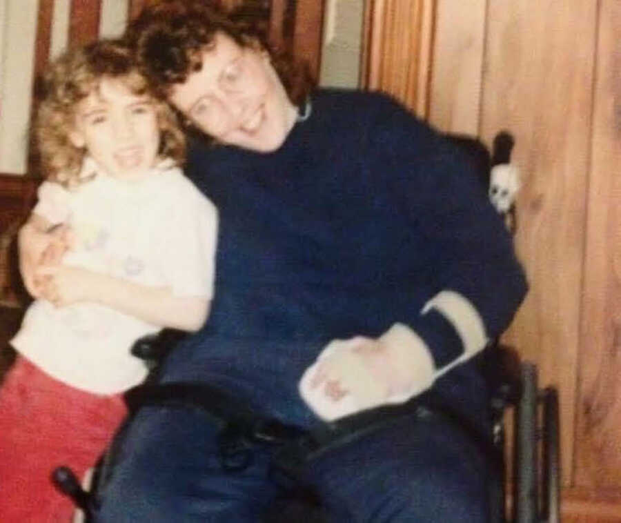 Smiling girl leaning on injured mother's lap