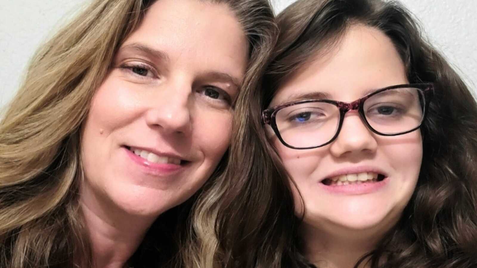 Special needs mom and daughter with autism smiling side by side