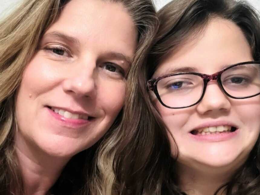 Special needs mom and daughter with autism smiling side by side